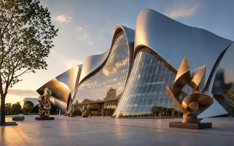 LVMH FR0000121014 architektonisches Render eines modernen Glasmuseums mit geschwungener Fassade und abstrakten Skulpturen - Foto: THN