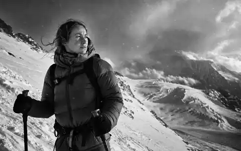 Moncler IT0005252207 black-and-white female mountaineer down jacket trekking poles snowy alpine altitude - Foto: THN