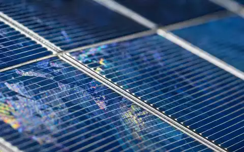 EDP PTEDP0AM0009 macro photovoltaic solar cell crystalline silicon grid iridescent rainbow structure closeup - Foto: THN