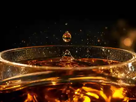 Pernod Ricard FR0000120693 — macro golden amber droplet suspended above whisky nosing glass - Foto: THN