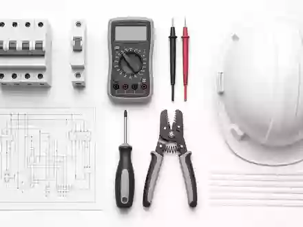 Schneider Electric FR0000121972 flatlay knolling of circuit breakers multimeter wiring schematic screwdriver and safety helmet - Foto: THN
