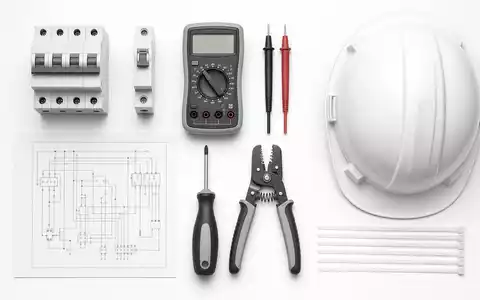 Schneider Electric FR0000121972 flatlay knolling of circuit breakers multimeter wiring schematic screwdriver and safety helmet - Foto: THN