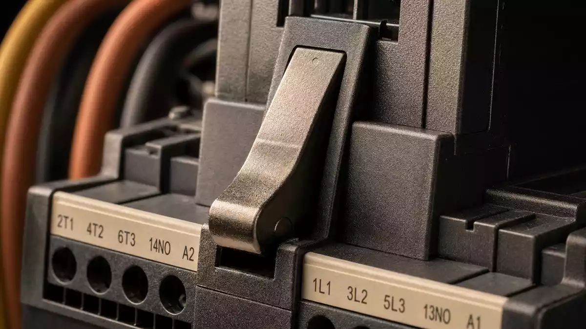 Extreme macro photo of industrial circuit breaker lever showing labeled terminals and molded plastic housing texture detail