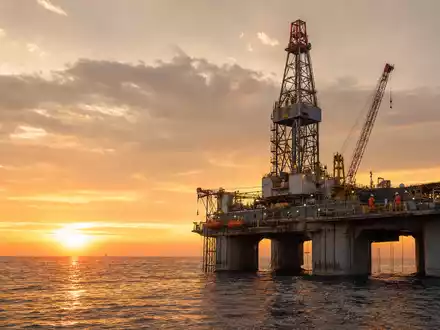 Eni IT0003128367 zeigt eine offshore Ölplattform im Mittelmeer bei goldenem Sonnenuntergang mit Bohrturm - Foto: THN