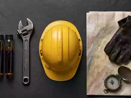 Eni IT0003128367 Flatlay mit Erdöl Probefläschchen Schraubenschlüssel Helm Geo Karte und Handschuhen - Foto: THN