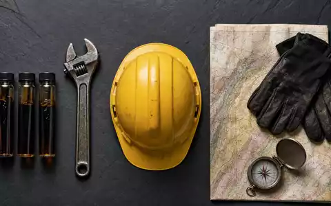 Eni IT0003128367 Flatlay mit Erdöl Probefläschchen Schraubenschlüssel Helm Geo Karte und Handschuhen - Foto: THN