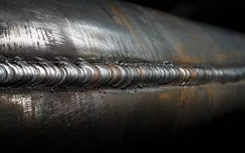 Eni IT0003128367 Makroaufnahme einer Pipeline Schweißnaht mit Stahltextur und dramatischem Lichtreflex auf Stahl - Foto: THN