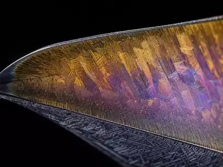 Safran FR0000073272 extreme macro of turbine blade leading edge with iridescent titanium gold thermal coating - Foto: THN