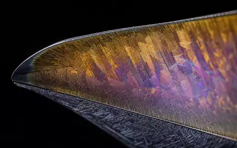 Safran FR0000073272 extreme macro of turbine blade leading edge with iridescent titanium gold thermal coating - Foto: THN