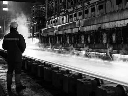 Saint-Gobain FR0000125007 Arbeiter mit Helm vor leuchtendem Float-Glas-Band in industrieller GlashĂŒtte schwarz-weiĂ - Foto: THN
