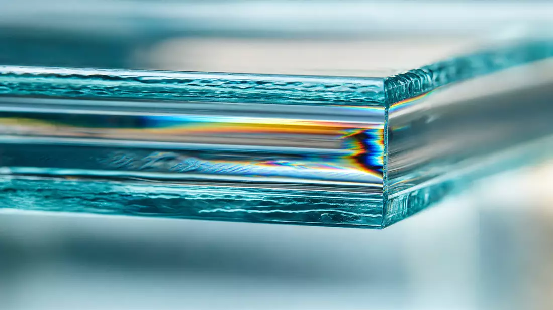 Extreme macro of glass edge cross-section showing prismatic light refraction, rainbow dispersion and layered structure