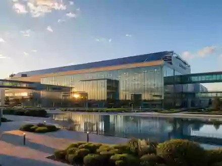 STMicroelectronics NL0000226223 modern semiconductor fab with solar roof and glass bridges at golden hour - Foto: THN
