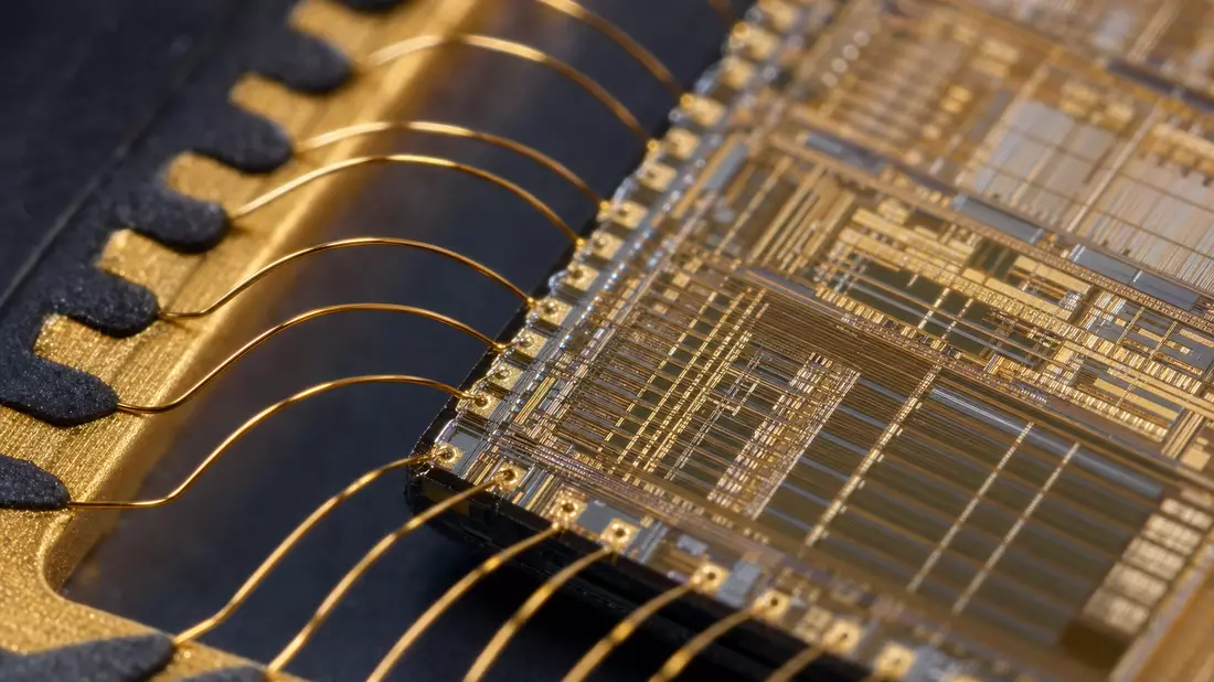 Extreme macro photograph of semiconductor microchip die with gold bond wire connections