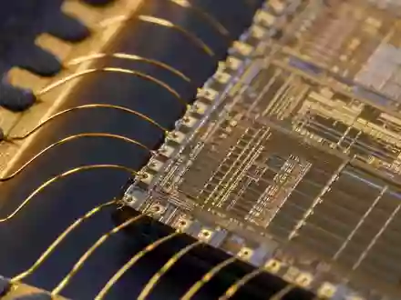 STMicroelectronics NL0000226223 extreme macro close-up microchip die with golden bond wire connections visible - Foto: THN