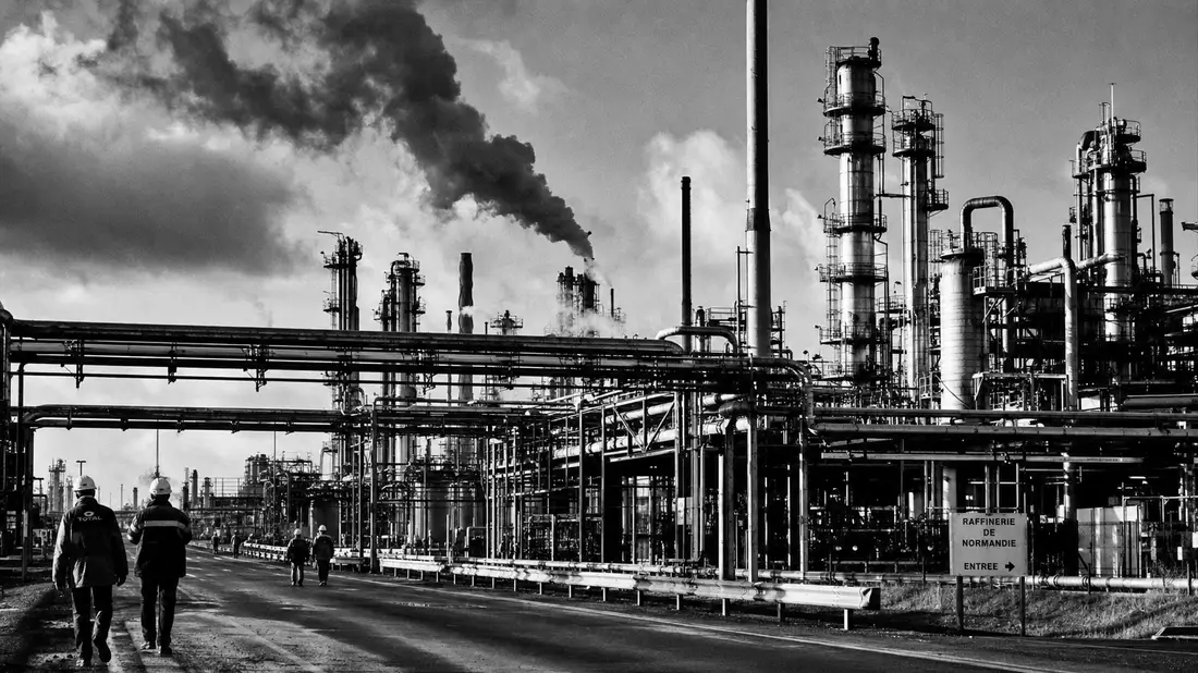 S/W-Dokumentarfoto einer Großraffinerie mit Destillationskolonnen, Pipelines und Arbeitern