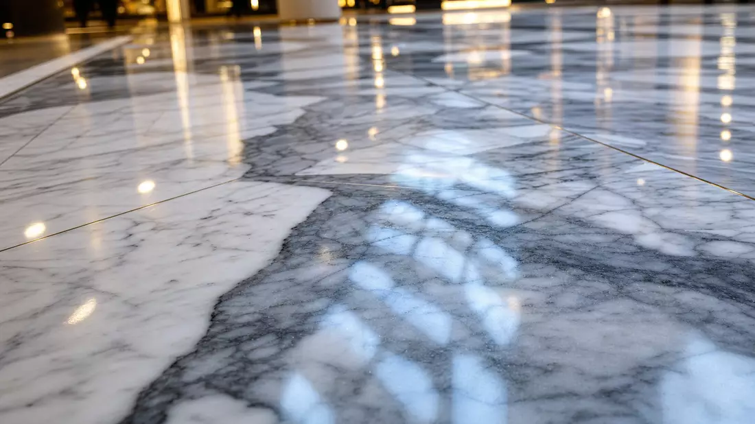 Makro-Foto von poliertem Marmorboden mit Lichtreflexionen im Mall-Inneren