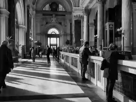 Intesa Sanpaolo IT0000072618 – Schwarz-Weiß-Reportage einer klassischen italienischen Bankschalter-Halle mit wartenden Kunden - Foto: THN