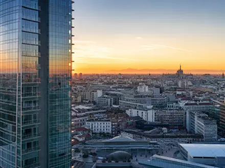UniCredit IT0005239360 – fotorealistische Panoramaaufnahme des Mailänder Porta-Nuova-Viertels mit modernem Wolkenkratzer und Dom-Silhouette im Abendhimmel - Foto: THN
