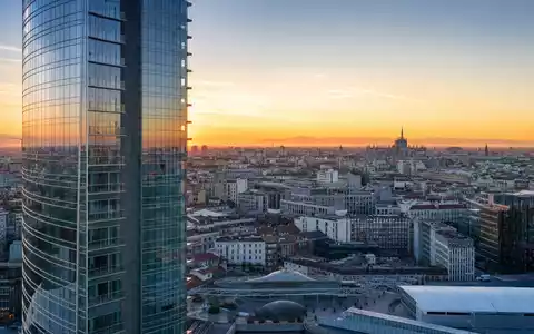 UniCredit IT0005239360 – fotorealistische Panoramaaufnahme des Mailänder Porta-Nuova-Viertels mit modernem Wolkenkratzer und Dom-Silhouette im Abendhimmel - Foto: THN