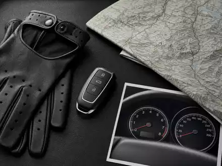 Flatlay mit Fahrzeugschlüssel, Lederhandschuhen, Alpenkarte und Tachometer-Cockpit-Print – Lifestyle-Editorial der BMW AG (ISIN DE0005190003) Automobilaccessoires - Foto: THN