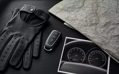 Flatlay mit Fahrzeugschlüssel, Lederhandschuhen, Alpenkarte und Tachometer-Cockpit-Print – Lifestyle-Editorial der BMW AG (ISIN DE0005190003) Automobilaccessoires - Foto: THN