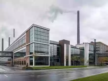 Architekturfoto eines modernen Industriegeländes mit Schornsteinen im Hannover-Industriestil – repräsentiert den norddeutschen Produktionsstandort der Continental AG (ISIN DE0005439004) - Foto: THN