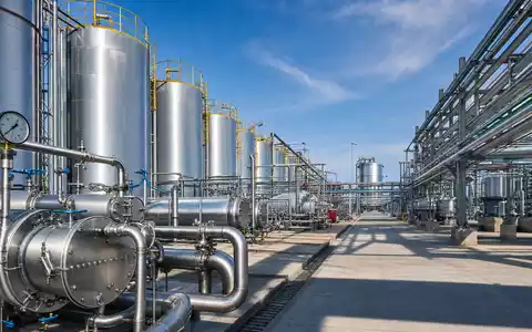 Fotorealistisches Chemie-Tanklager mit Edelstahltanks und Rohrleitungen bei Tageslicht – repräsentativ für Brenntag SE (ISIN DE000A1DAHH0) als globalen Chemiedistributor - Foto: THN