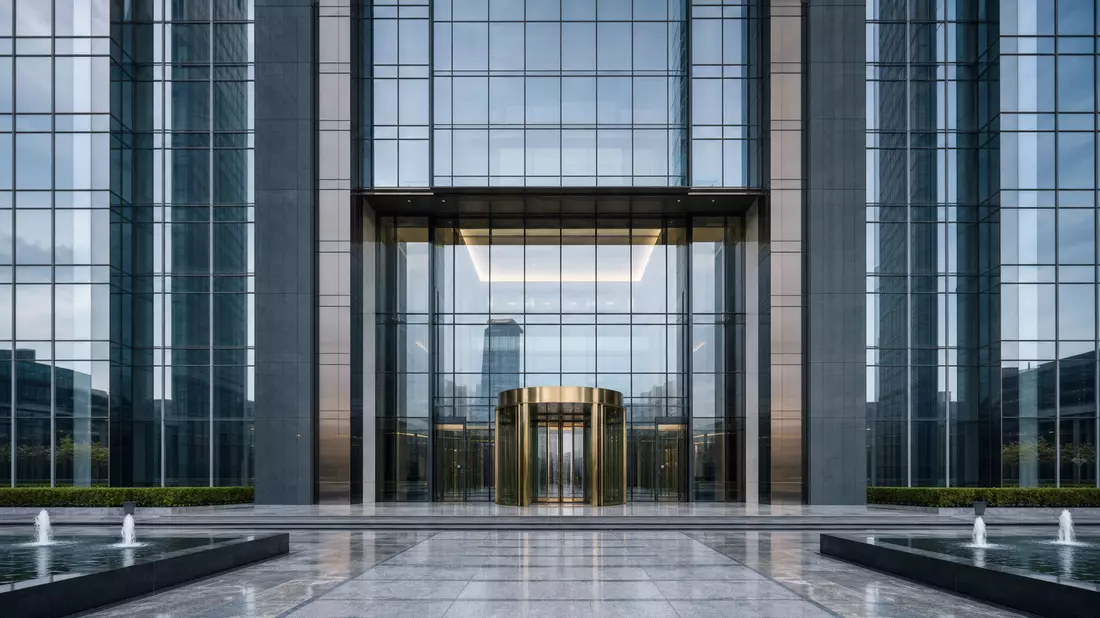 Moderner Bankgebäude-Eingang mit Glasfassade und goldener Drehtür
