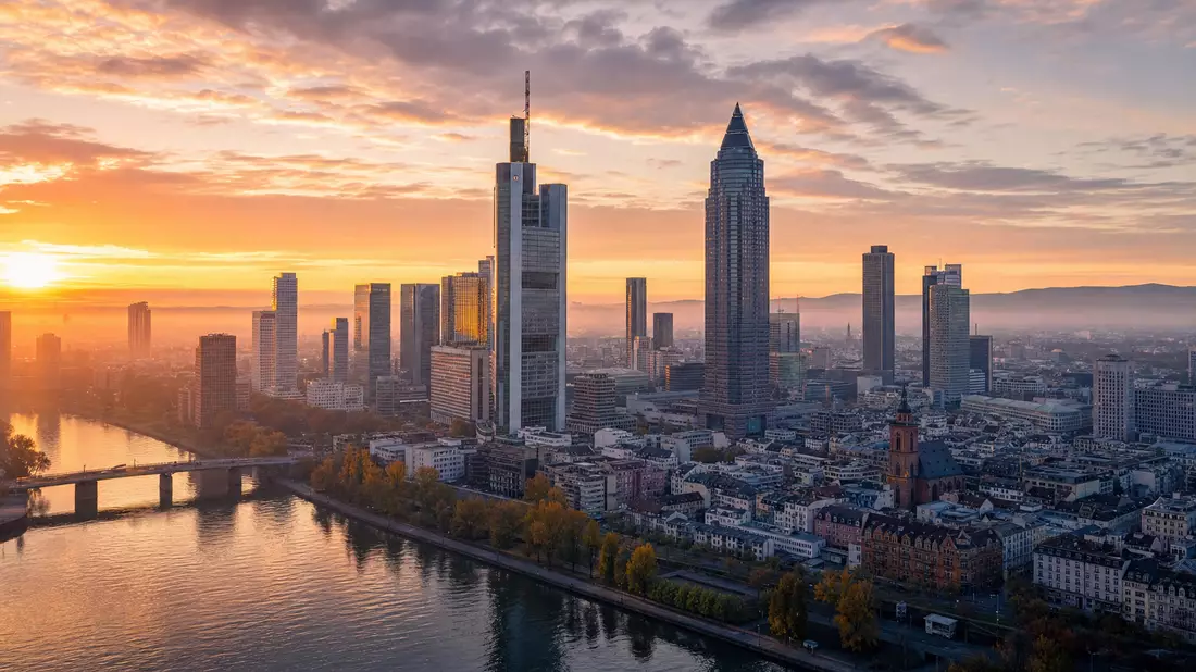 Frankfurter Bankenviertel bei Sonnenaufgang mit Hochhaustürmen und Main-Fluss