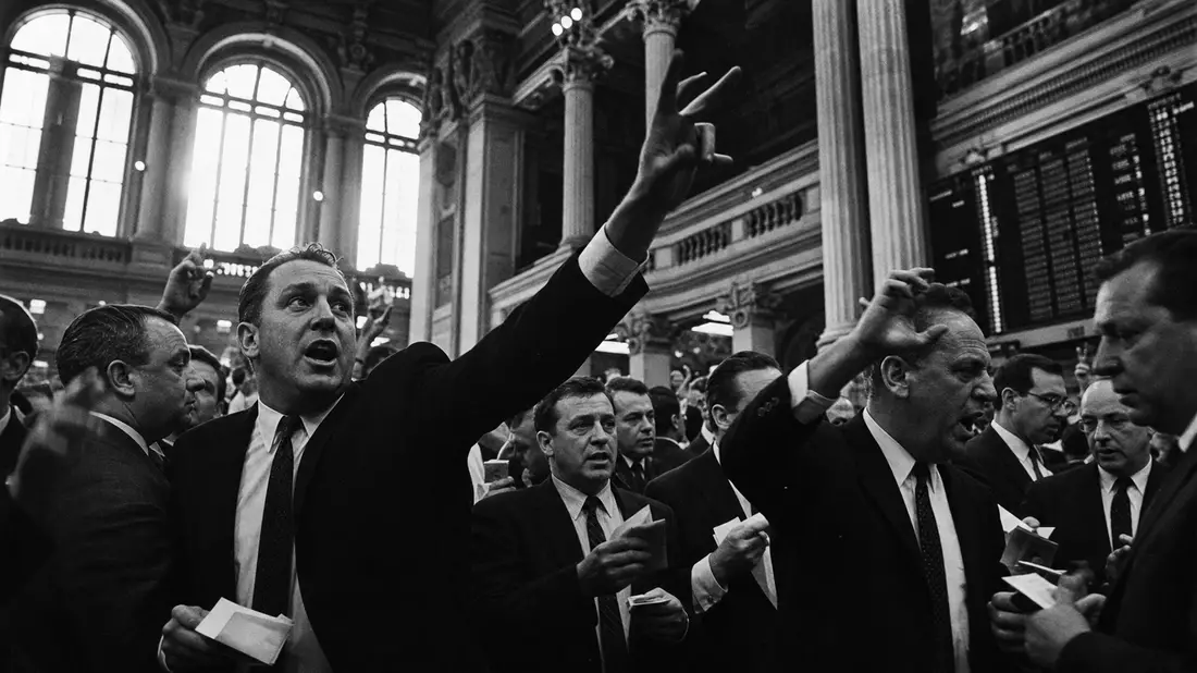 Schwarzweiß-Reportage von Börsenhändlern mit Gestikulation im historischen Börsensaal