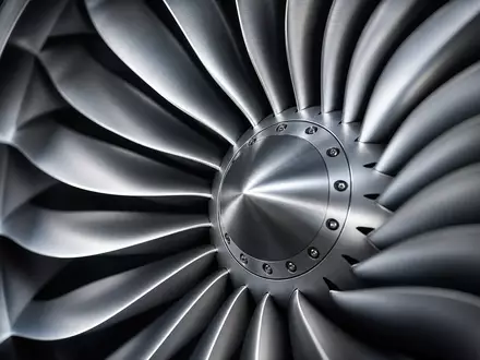 Makrofotografie für Deutsche Lufthansa AG (ISIN DE0008232125): Extremnahe Detailaufnahme der Schaufeln eines Strahltriebwerks-Fans aus poliertem Titan, radiales Muster, dramatisches seitliches Studiolight, kalt-metallische Töne - Foto: THN