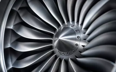Makrofotografie für Deutsche Lufthansa AG (ISIN DE0008232125): Extremnahe Detailaufnahme der Schaufeln eines Strahltriebwerks-Fans aus poliertem Titan, radiales Muster, dramatisches seitliches Studiolight, kalt-metallische Töne - Foto: THN