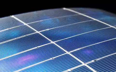 Extreme Nahaufnahme einer monokristallinen Silizium-Solarzelle. Das Bild zeigt das feine Raster aus Silberbusbars und Fingerleitungen auf der tiefschwarzblau schimmernden Oberfläche sowie irisierenden Farbeffekte der Antireflexbeschichtung in Blau und Violett. Diese Detailaufnahme steht für die Photovoltaik-Technologiekompetenz im Portfolio von E.ON SE (ISIN DE000ENAG999) - Foto: THN