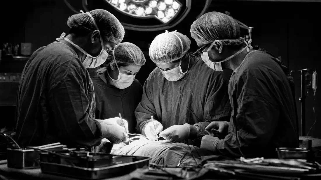 Fresenius SE – Schwarzweiß-Reportage: OP-Team in Aktion mit Beleuchtung und Instrumenten