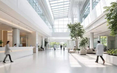 Ein helles, weitläufiges Klinik-Atrium mit Glasdach und modernem Eingangsbereich – architektonisch vergleichbar mit den Dialysezentren und Gesundheitseinrichtungen von Fresenius Medical Care AG (ISIN DE0005785802) weltweit - Foto: THN