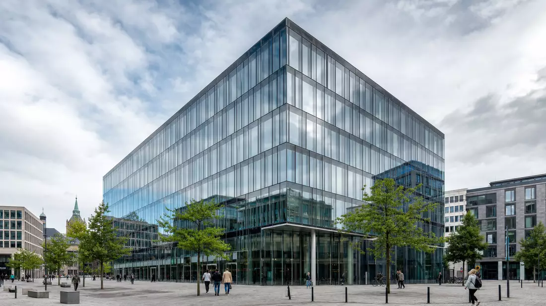 Modernes Glas- und Stahlbürogebäude im europäischen Stadtzentrum mit klarem Himmel