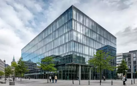 Architekturfoto eines modernen Glasgebäudes in Hannover – symbolisiert den Hauptsitz und die Solidität der Hannover Rück SE (ISIN DE0008402215), einem der weltweit führenden Unternehmen in der Rückversicherungsbranche - Foto: THN