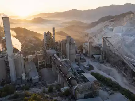 Luftaufnahme eines Zementwerks bei Sonnenaufgang – Heidelberg Materials AG (ISIN DE0006047004) ist ein weltweit führender Hersteller von Zement, Kies und Baustoffen mit Sitz in Heidelberg - Foto: THN