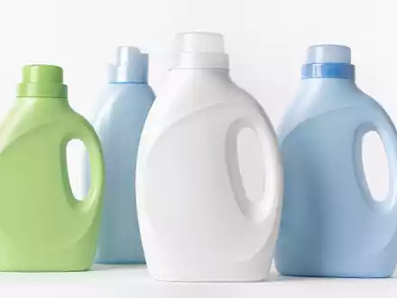 Fotorealistisch inszenierte generische Waschmittelflaschen aus Kunststoff in Blau, Grün und Weiß auf weißem Studio-Hintergrund – ein typisches Produktbild aus dem Segment Wasch- und Reinigungsmittel, wie es für die Henkel AG & Co. KGaA (ISIN DE0006048432) und ihr Konsumgütergeschäft steht - Foto: THN