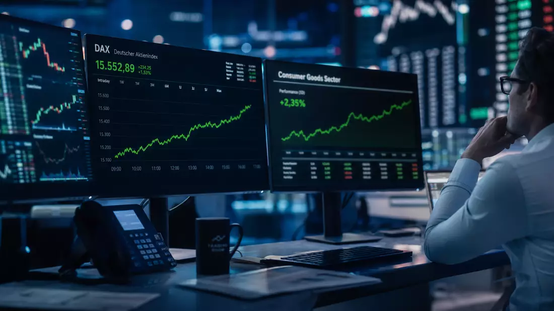 Trader vor Monitoren mit DAX-Chart und Consumer Goods Sector Index in blau beleuchtetem Trading-Raum