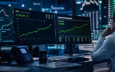 Stimmungsvolles Börsen-Editorial-Foto eines Traders vor mehreren Monitoren mit DAX-Chart und Consumer-Goods-Sektor-Index – illustriert die Kapitalmarktpräsenz der Henkel AG & Co. KGaA (ISIN DE0006048432) als börsennotiertes DAX-Unternehmen im deutschen Leitindex - Foto: THN