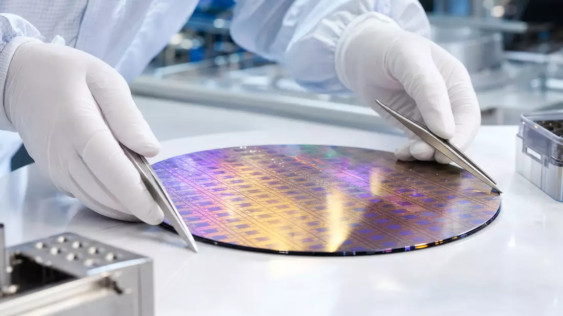 Silizium-Wafer mit Lichtreflexionen und Pinzetten im Halbleiter-Reinraum