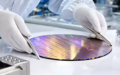 Fotorealistisches Reinraumbild zeigt einen Silizium-Wafer mit irisierendem Lichtspiel, der von behandschuhten Händen mit Pinzetten gehalten wird – ein zentrales Produktionsmotiv der Halbleiterindustrie, wie sie Infineon Technologies AG (ISIN DE0006231004) betreibt - Foto: THN