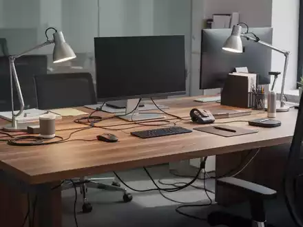 Ein aufgeräumter, moderner Schreibtisch mit Holzoberfläche, ergonomischen Accessoires und gut organisiertem Kabelmanagement. - Foto: über boerse-global.de