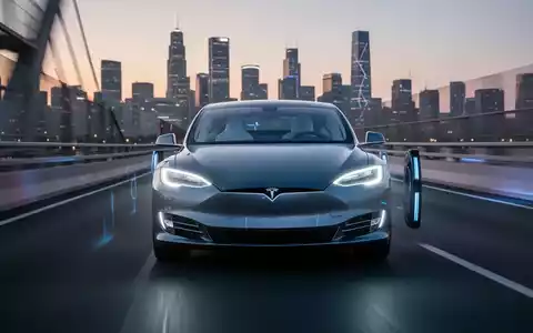 Ein futuristisches, elegantes Tesla-Auto fährt autonom auf einer modernen Autobahn bei Dämmerung, die Scheinwerfer leuchten. - Foto: über boerse-global.de