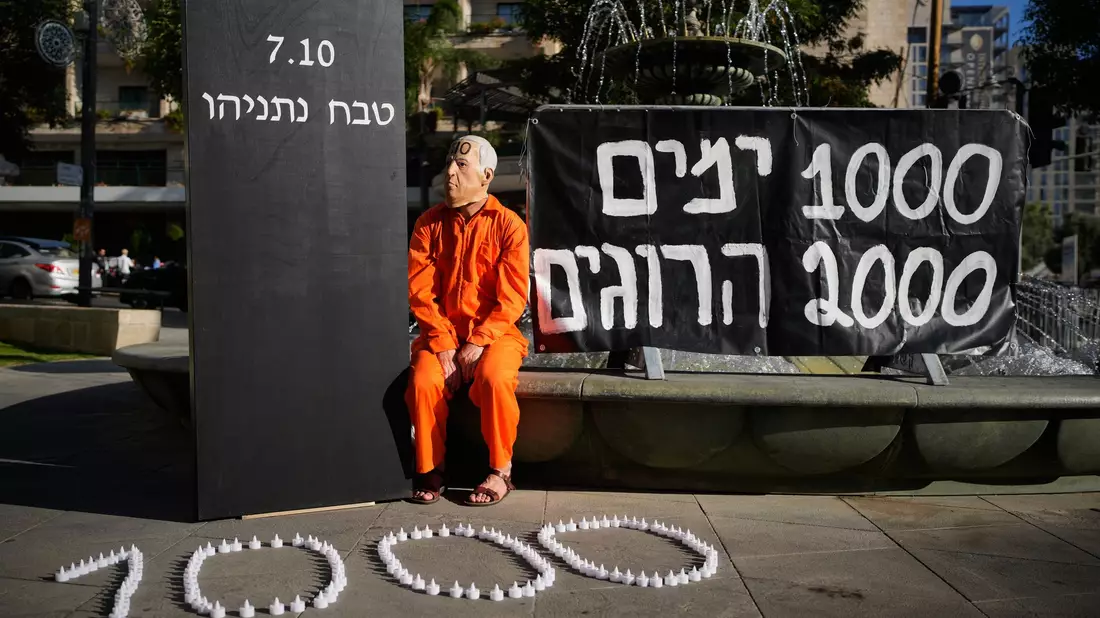 Demonstrant mit einer Maske, die den israelischen Ministerpräsidenten Benjamin Netanjahu darstellt, während einer Protestkundgebung 1000 Tage nach dem beispiellosen Hamas-Überfall auf Israel am 7. Oktober 2023.  - Bild: Ohad Zwigenberg/AP/dpa