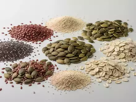 Eine Nahaufnahme von verschiedenen gesunden Samen und Körnern, darunter Chiasamen, Leinsamen, Kürbiskerne, Sonnenblumenkerne, Sesamsamen und Haferkleie. - Foto: über boerse-global.de