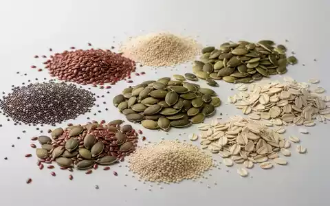Eine Nahaufnahme von verschiedenen gesunden Samen und Körnern, darunter Chiasamen, Leinsamen, Kürbiskerne, Sonnenblumenkerne, Sesamsamen und Haferkleie. - Foto: über boerse-global.de