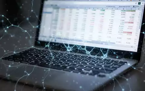 Nahaufnahme einer Laptop-Tastatur mit unscharfem Bildschirm, der Finanzdaten in einer Tabelle zeigt, überlagert mit abstrakten KI-Mustern. - Foto: über boerse-global.de