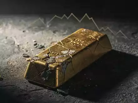 Ein teilweise angelaufener Goldbarren liegt auf einer dunklen Oberfläche, dramatisch beleuchtet, was einen Rückgang symbolisiert. - Foto: über boerse-global.de